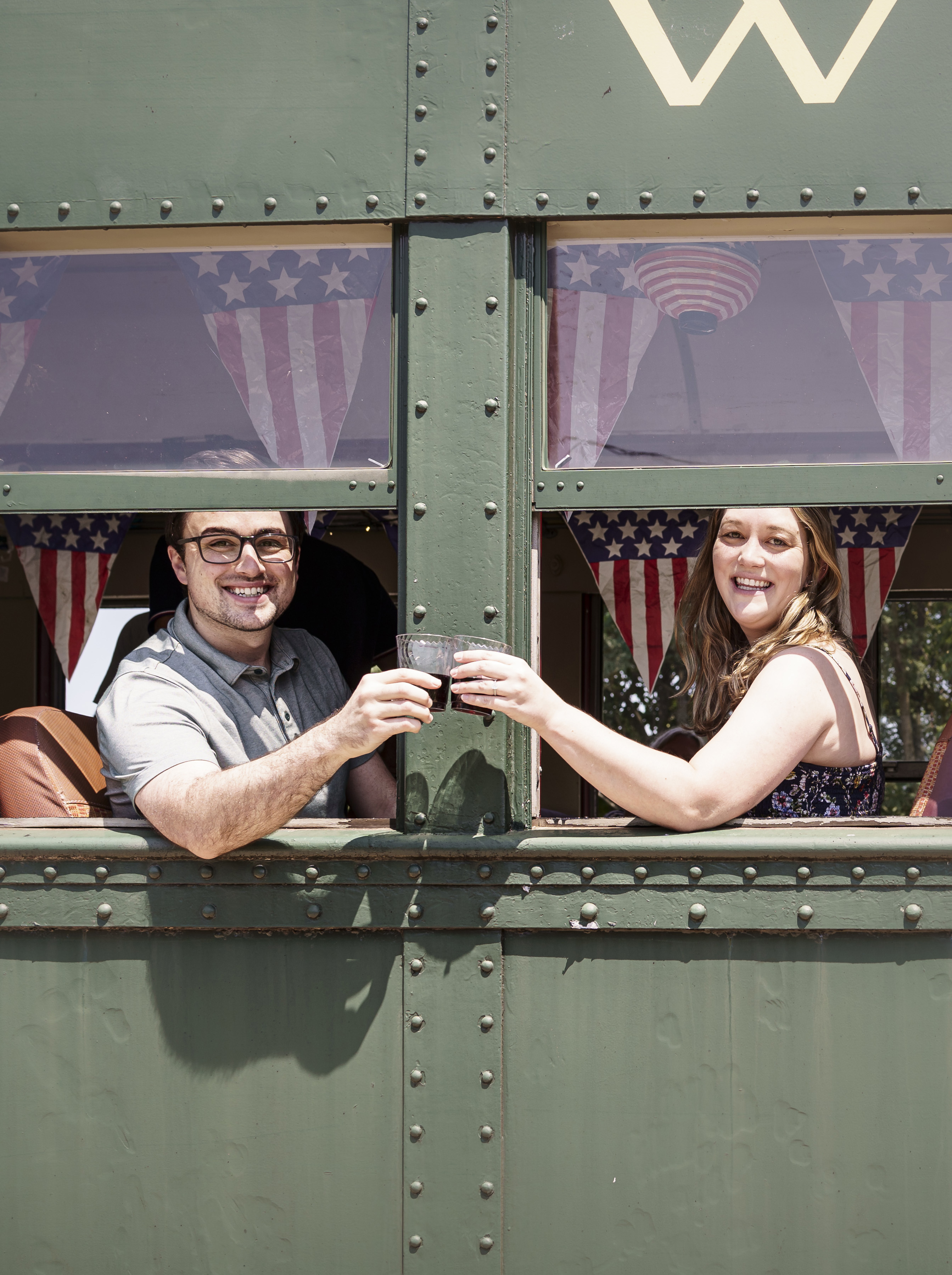 Couple enjoying wine aboard a train in Glen Mills, Red Brick Winery wine experience